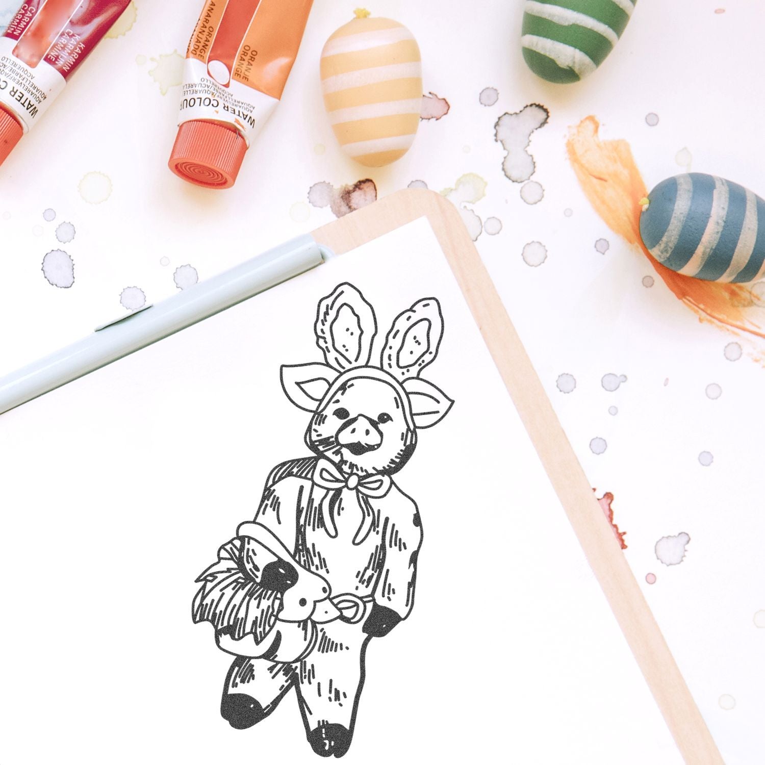 Watercolor paints and sketchbook with cute pig in bunny costume illustration for Easter art project