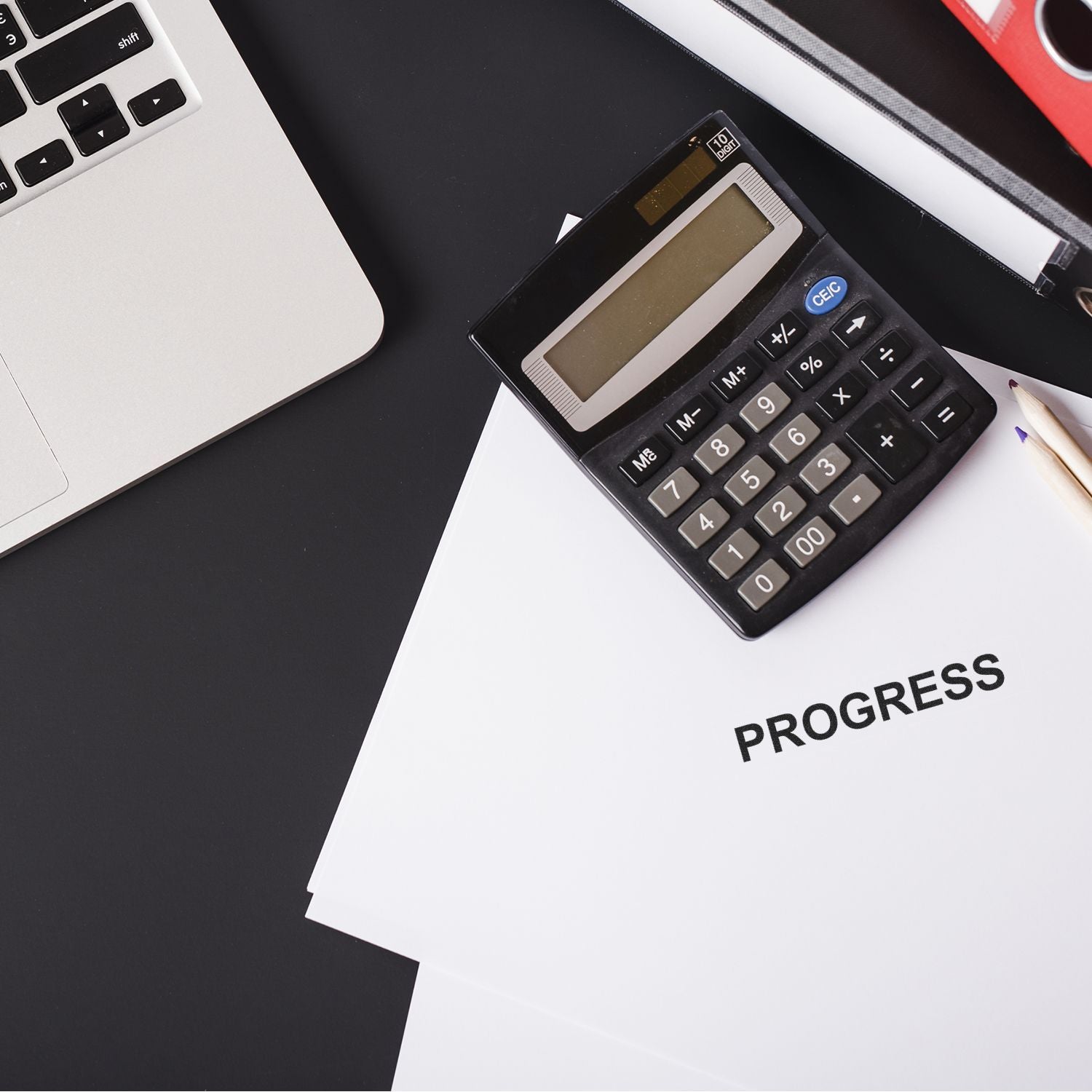 Calculator on progress report with laptop and office desk accessories, business finance planning and productivity concept