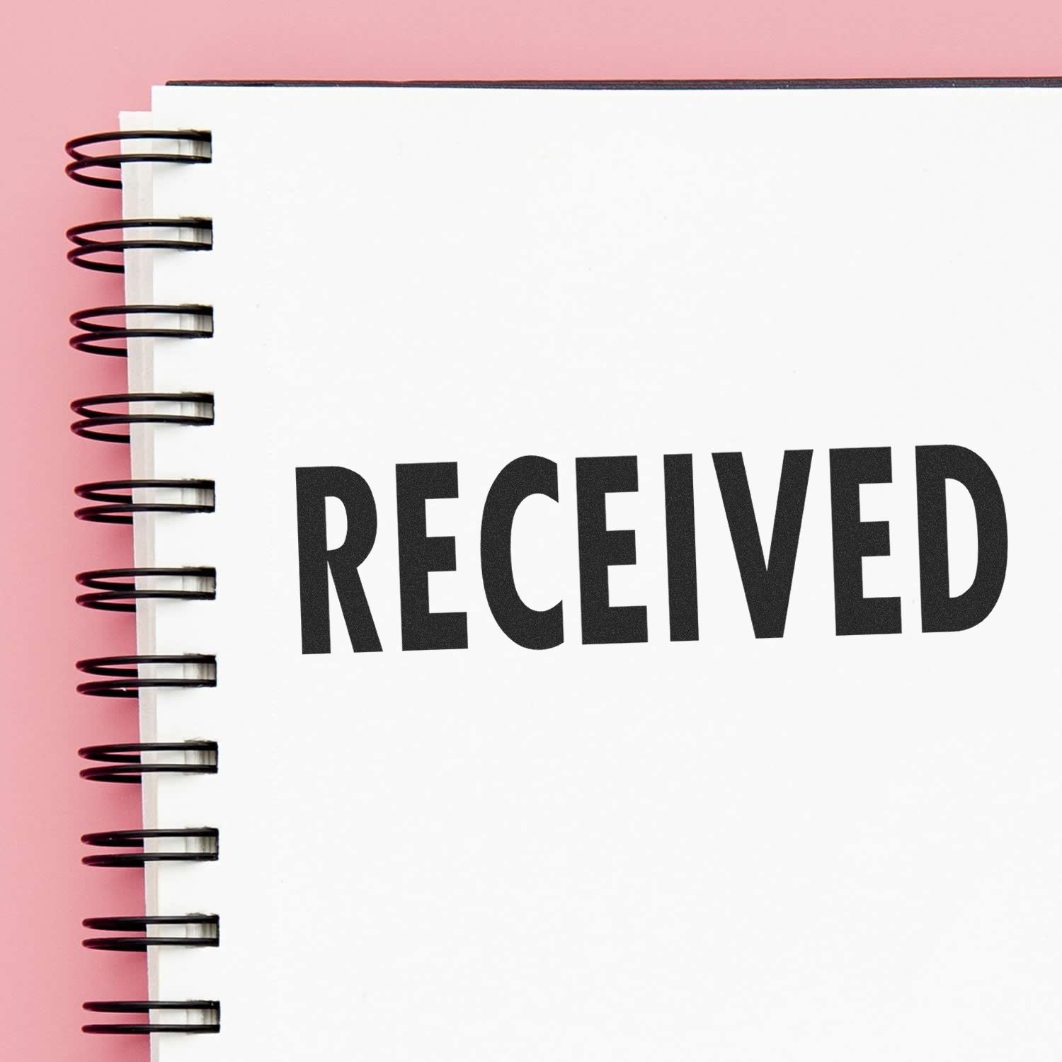 Notebook page with spiral binding and bold text RECEIVED, indicating confirmation of document receipt or status update.