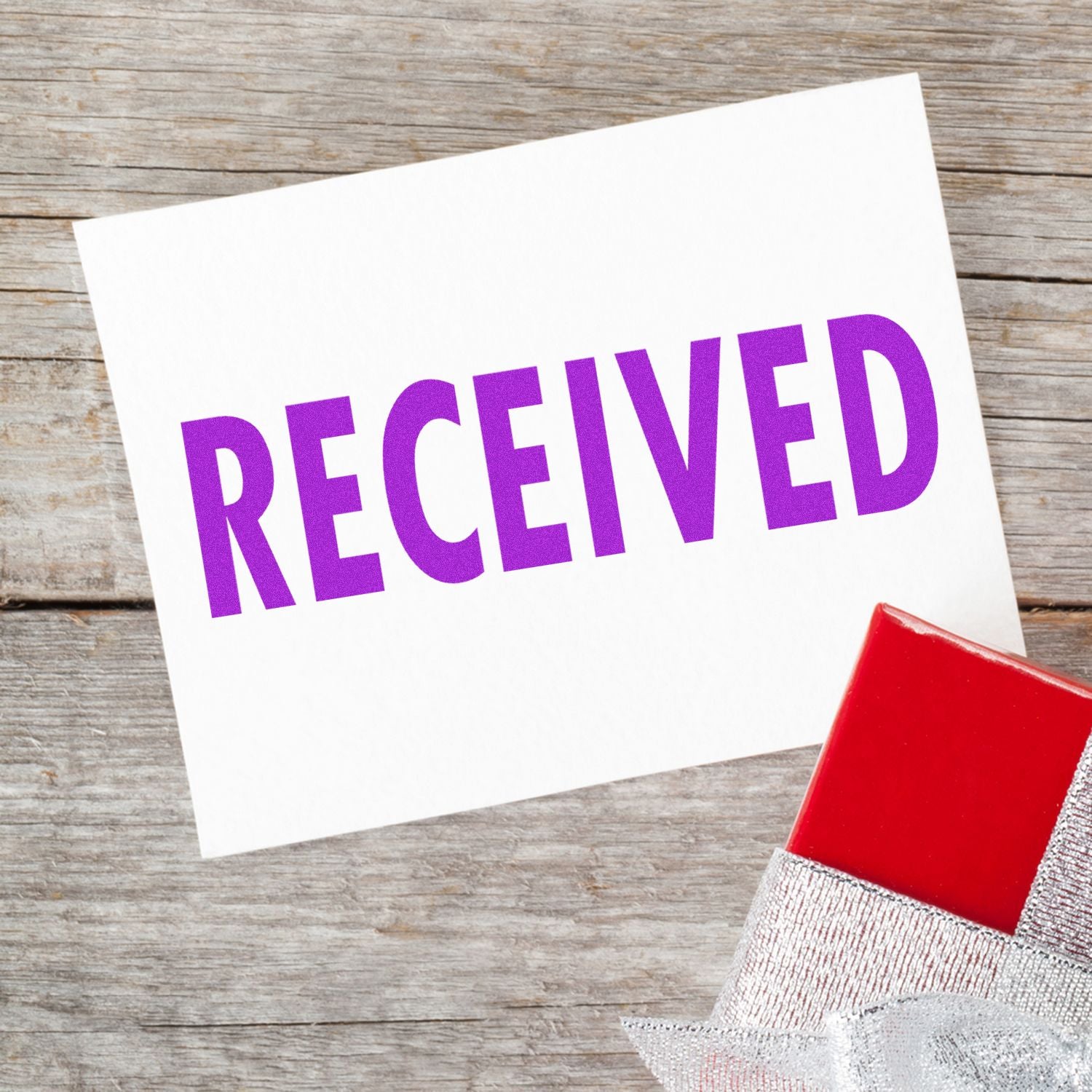 Received word on a white card with a red gift box on rustic wooden background