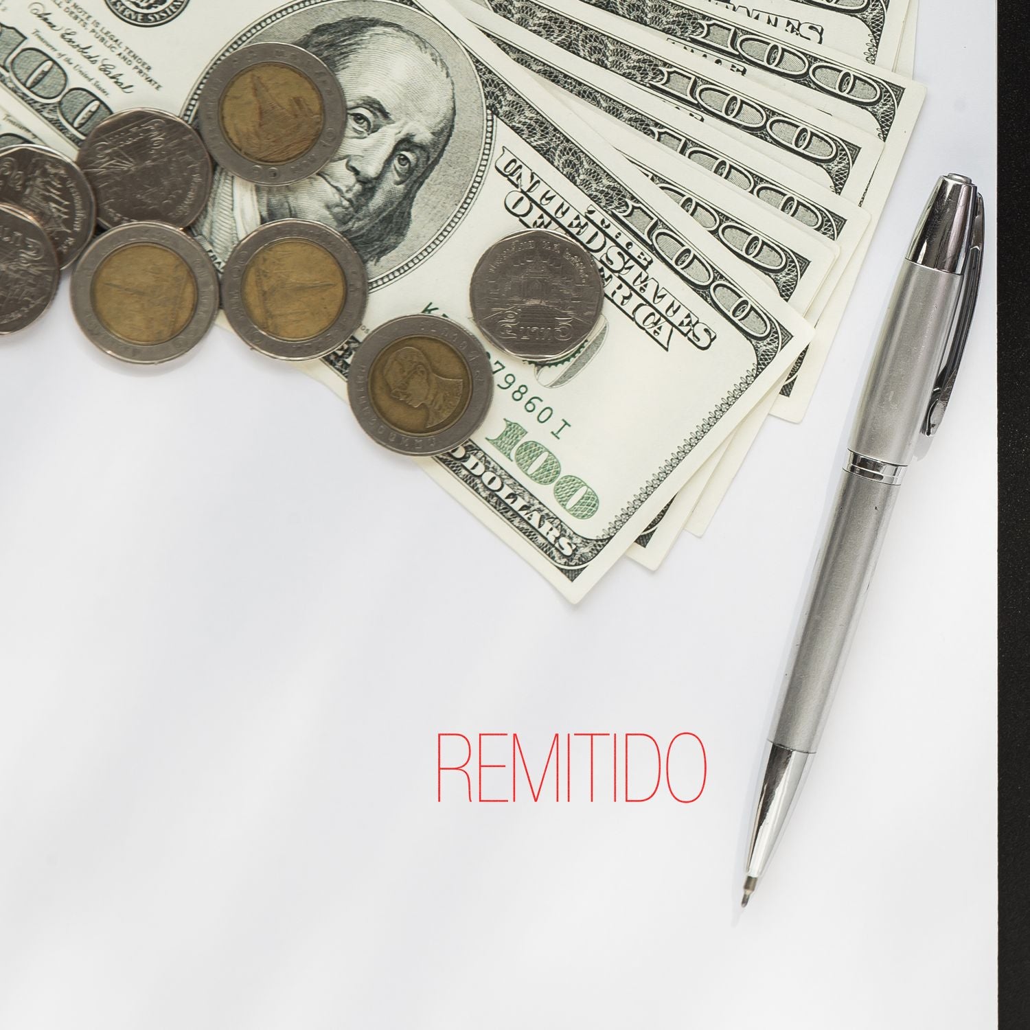 U.S. dollar bills and coins with a pen on a remitted payment document, financial transaction concept.