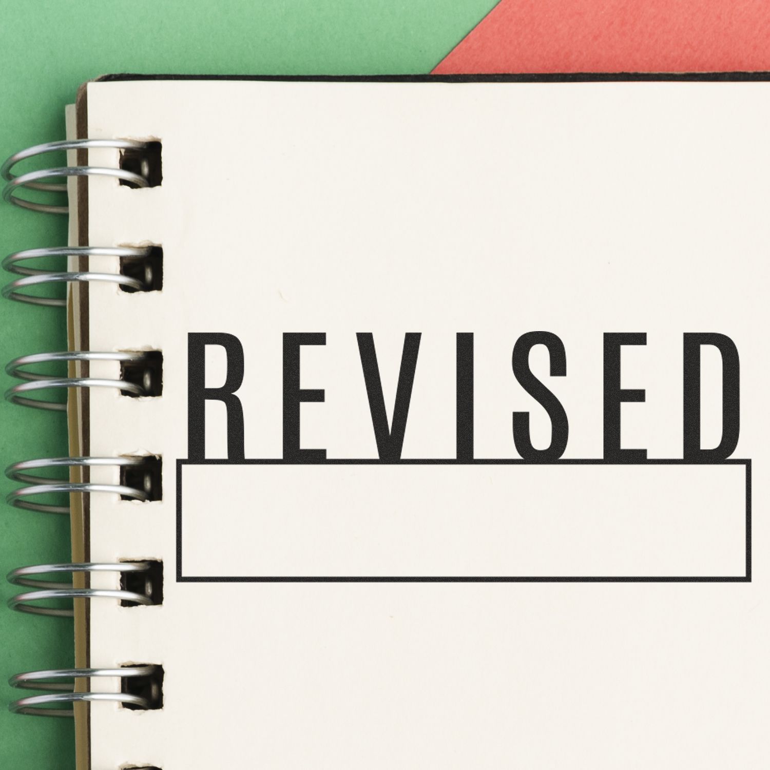 Notebook with REVISED title on cover, signaling a revised document or paperwork version for editing, review, and updates.