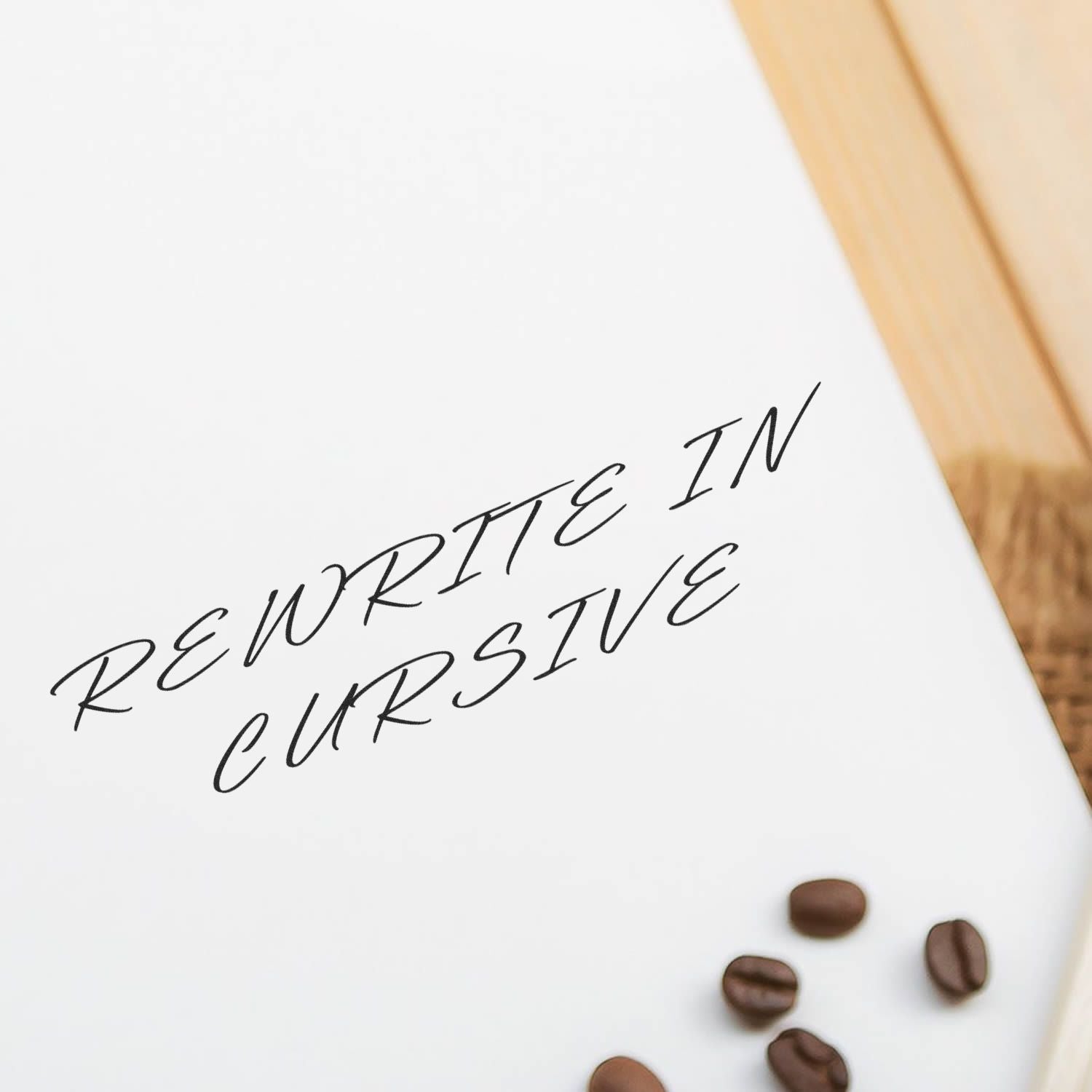 White notebook page with rewrite in cursive handwritten text and coffee beans on a wooden background.