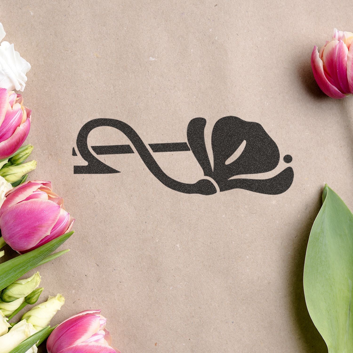 Pink tulips framing a black logo on kraft paper background, elegant floral branding design.