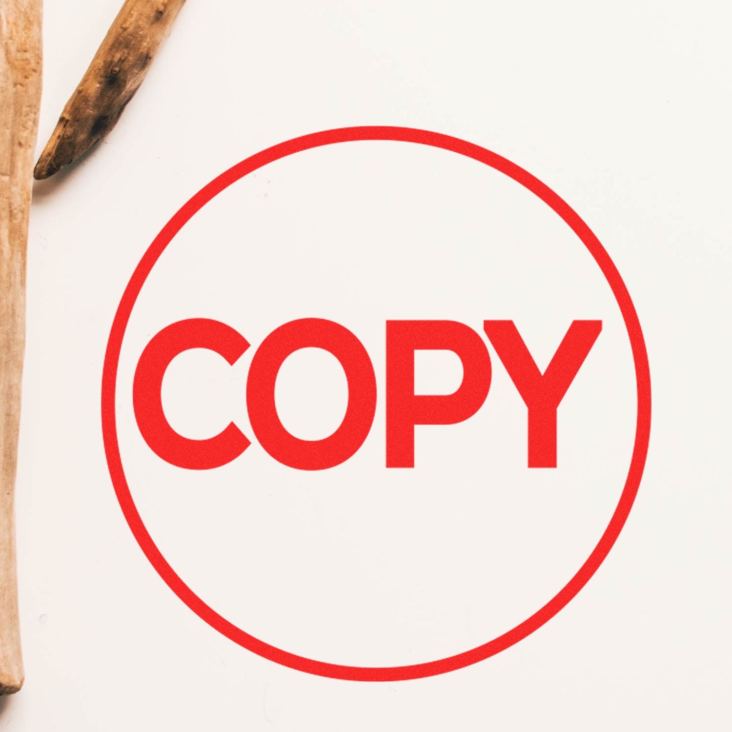 Red COPY icon in a circle on a white background with wooden pencils at the edge.