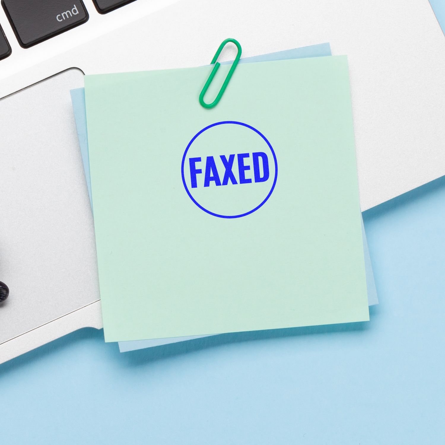 FAXED stamped sticky note on an office desk with paperclip and keyboard, document management and business paperwork concept