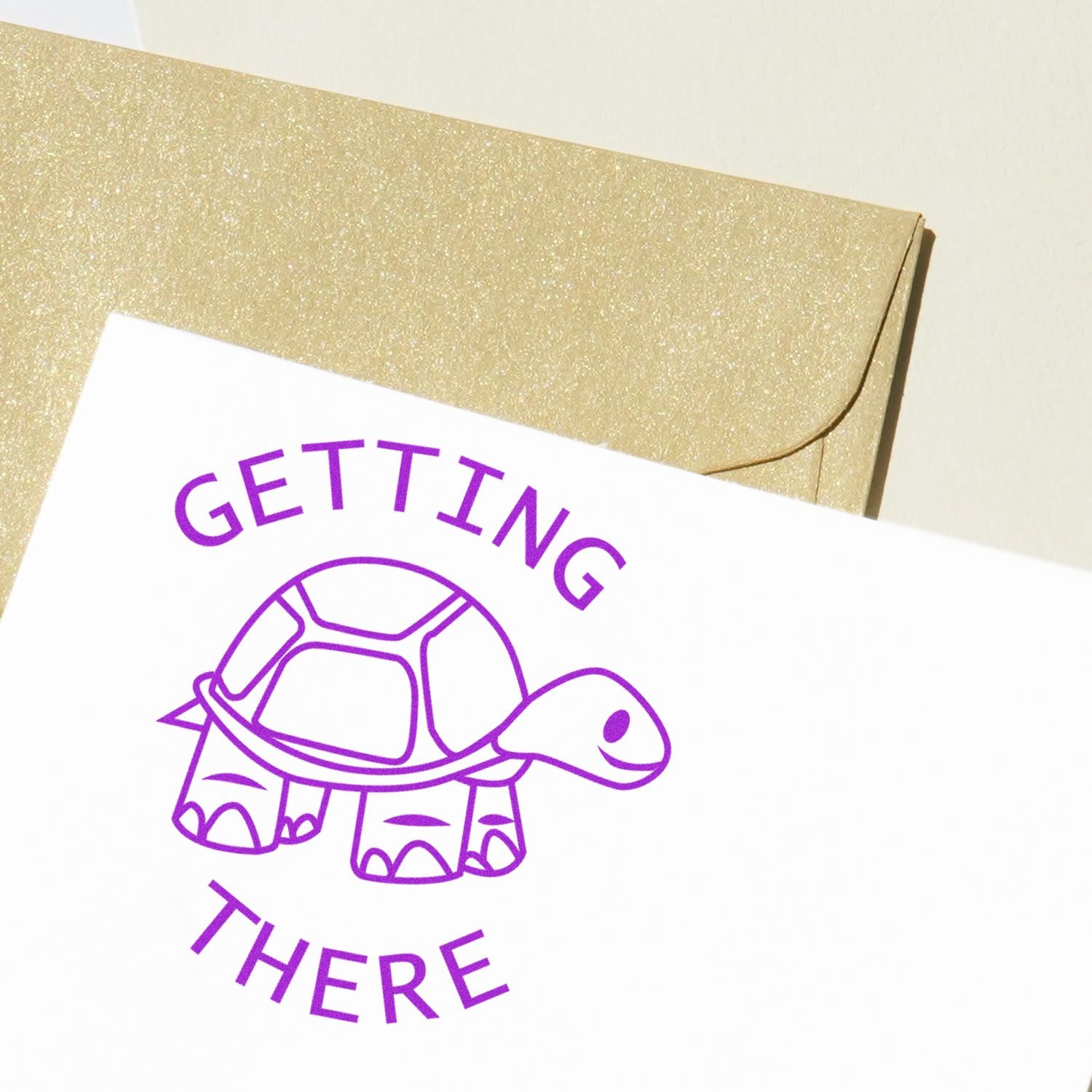 Gold glitter envelope with a purple turtle Getting There card, fun inspirational invitation design.