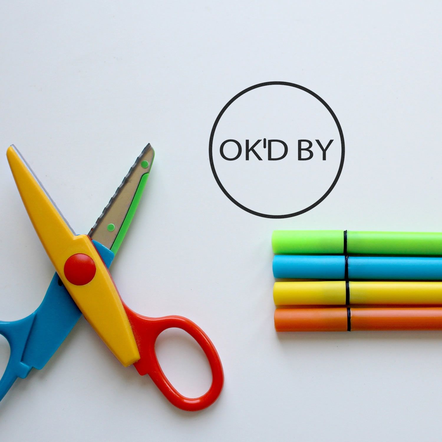 Colorful kids scissors and markers with OKd by approval stamp on white background