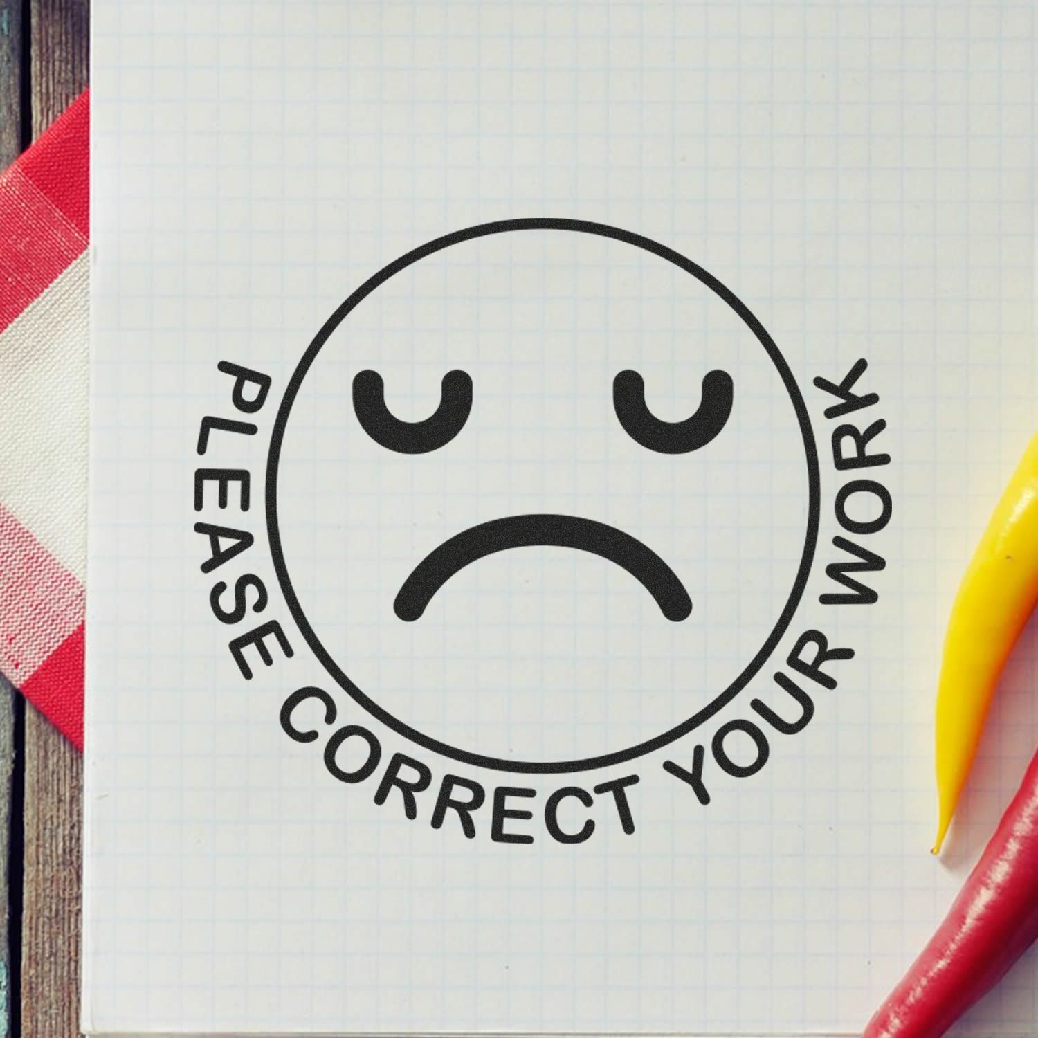 Sad face graphic with Please correct your work text on a notebook page, school feedback concept with colorful markers.