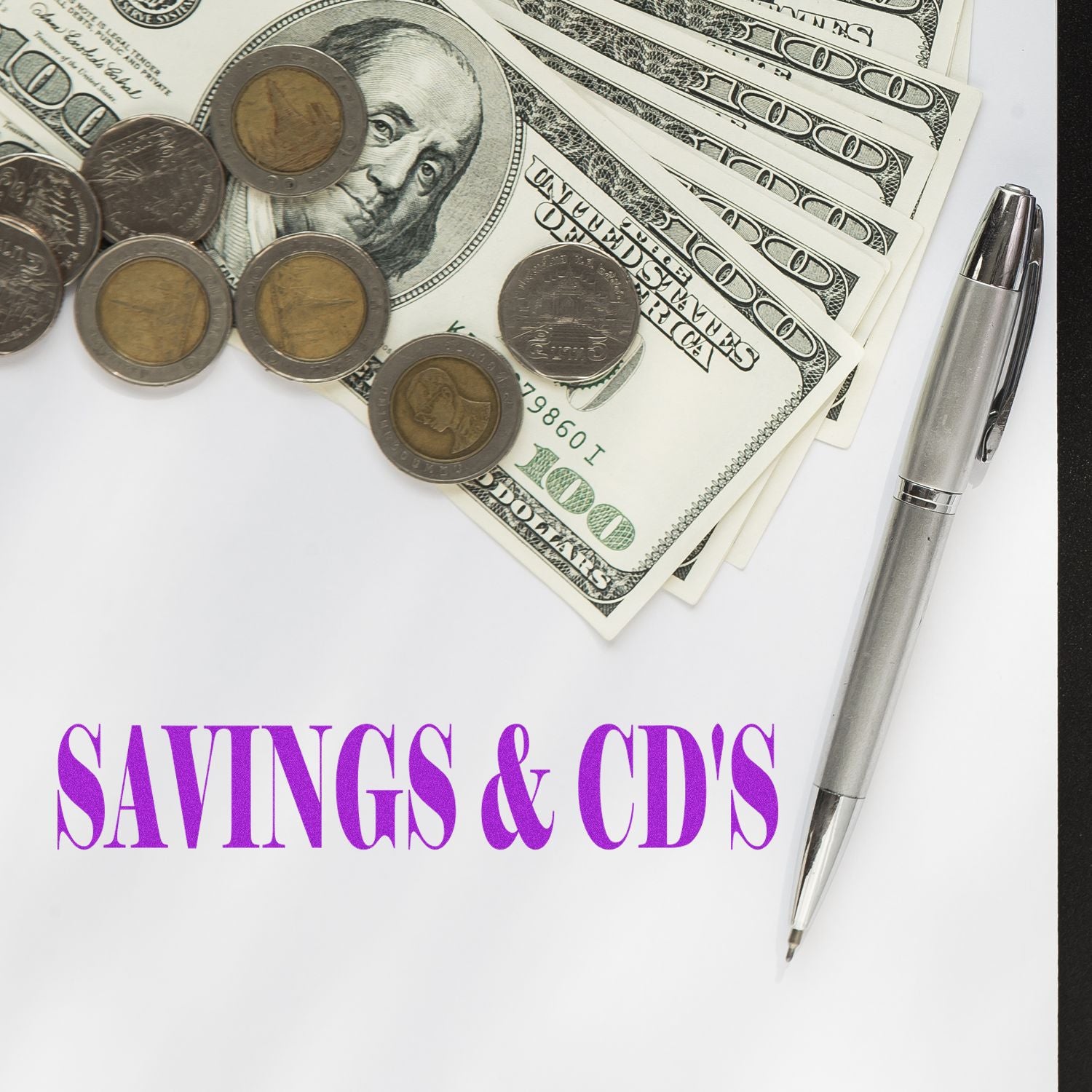 Savings and CDs concept with U.S. dollar bills, coins, and a pen on a financial document.