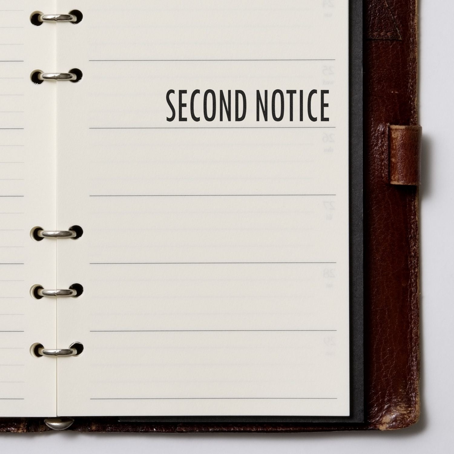 Second notice document heading on open notebook, signaling a formal reminder or follow-up action.