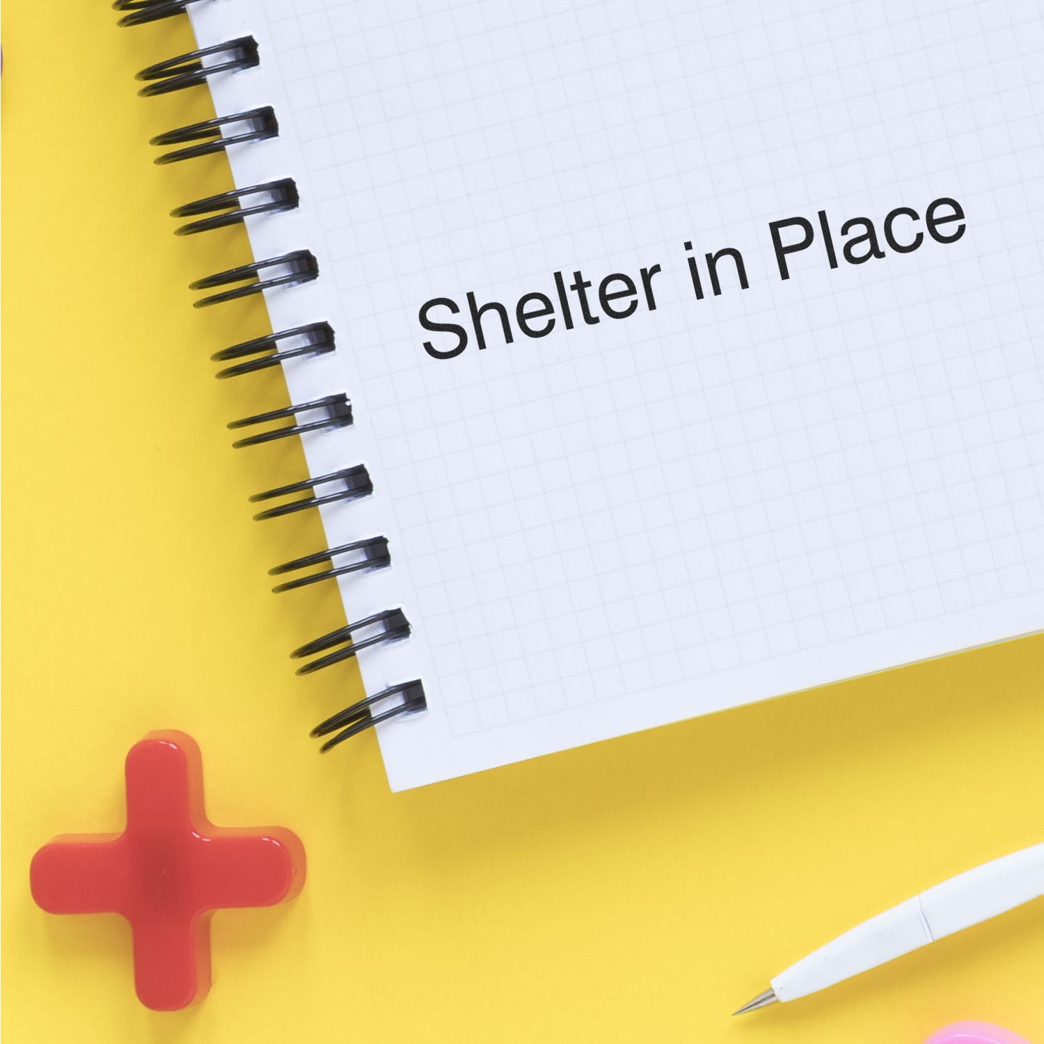 Shelter in Place emergency preparedness on notebook page with red cross, promoting safety and staying indoors during outbreaks.