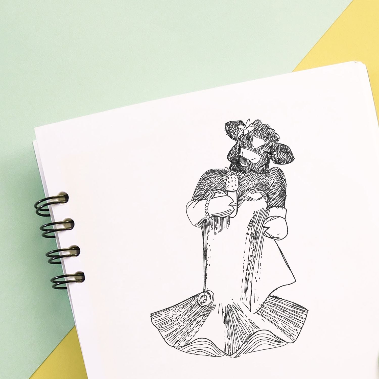 Hand-drawn cute cartoon animal holding an ice cream cone in a spiral notebook on a pastel background.