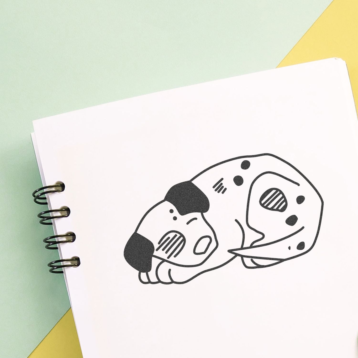 Cute sleeping puppy illustration in a spiral notebook on a pastel background, simple dog line art design.