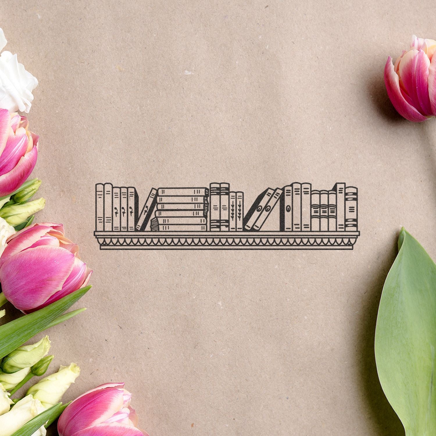 Floral flat lay with pink tulips framing a minimalist bookshelf illustration on kraft paper background.