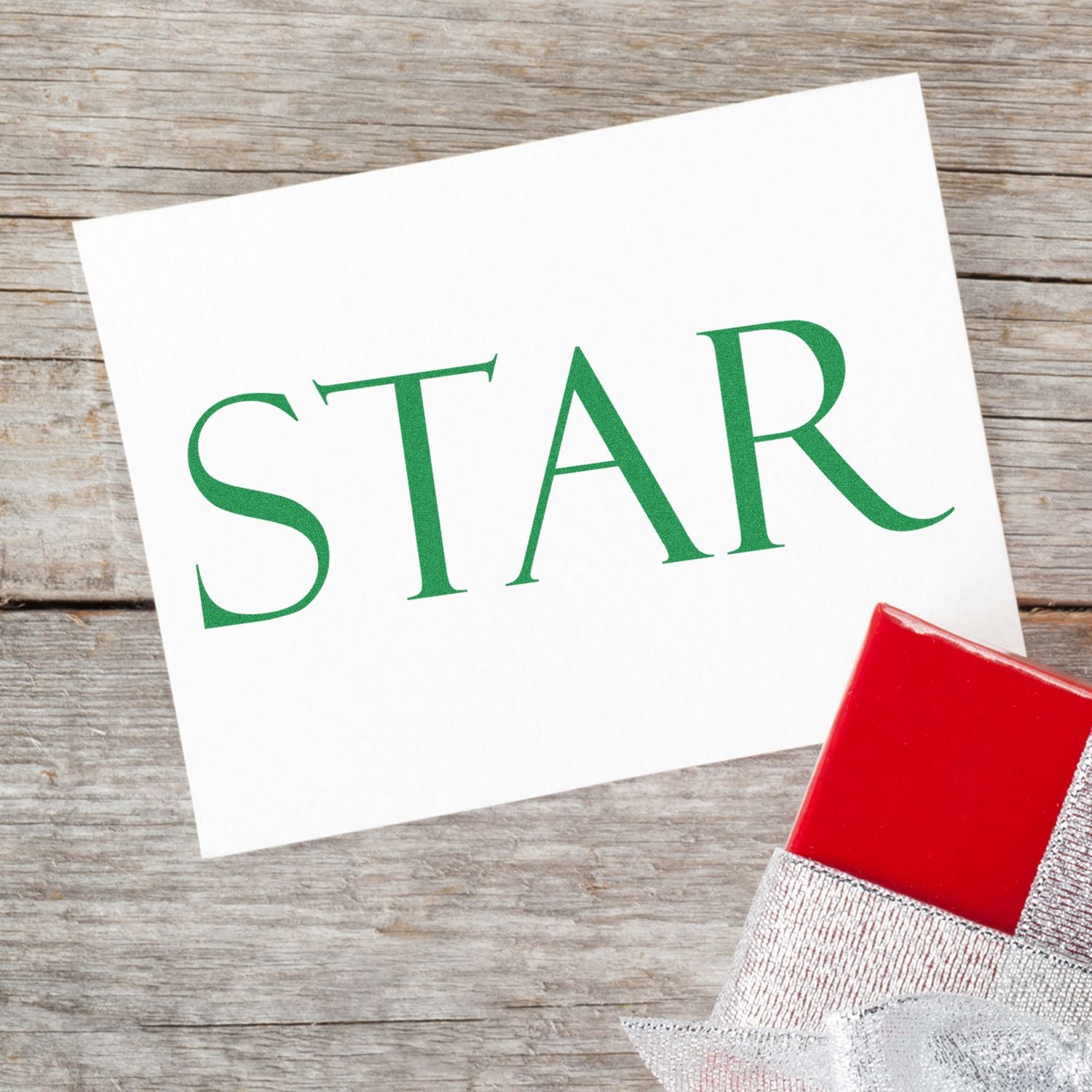 Christmas holiday star greeting card on wooden background with green STAR lettering and red Santa hat, festive celebration decor.