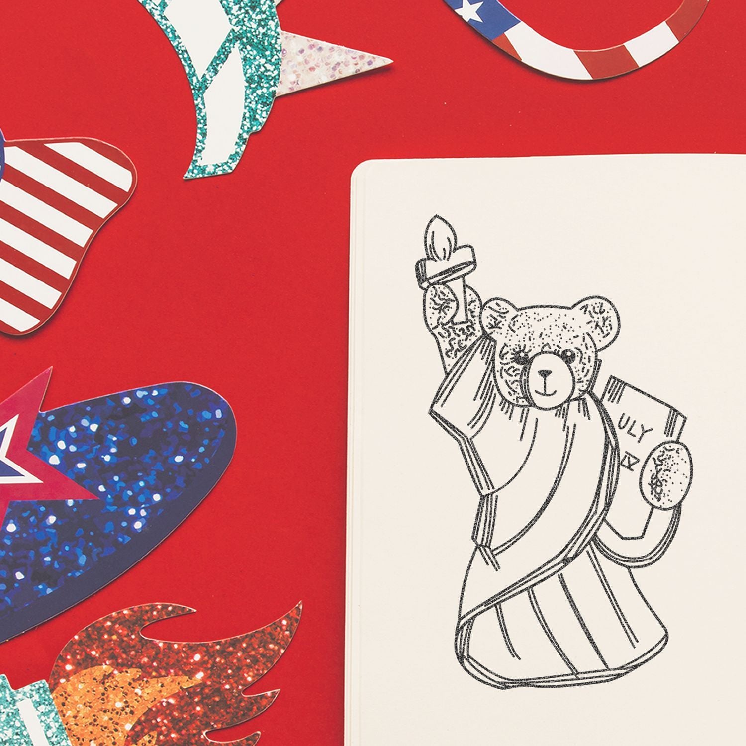Teddy bear coloring page on a red background with patriotic red, white and blue paper decorations