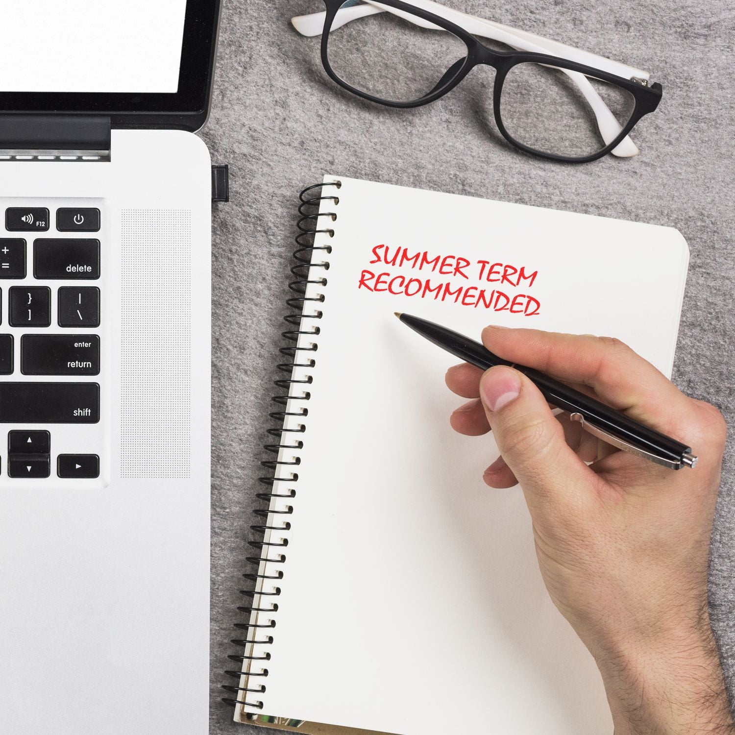 Handwriting in notebook: Summer Term Recommended, with pen, calculator, and eyeglassesschool term planning and study prep.