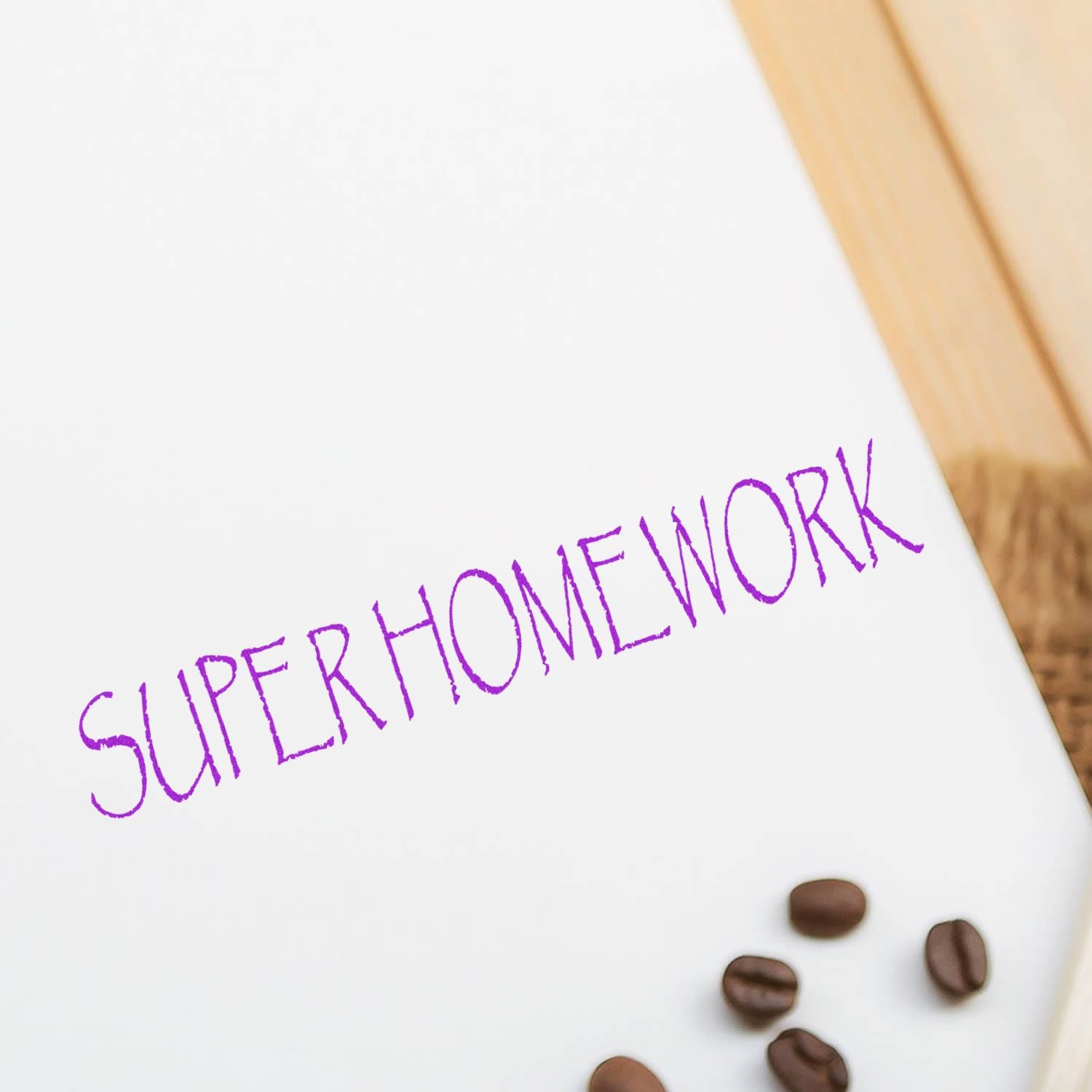 White notebook with Super Homework text, coffee beans, and wooden desk background.
