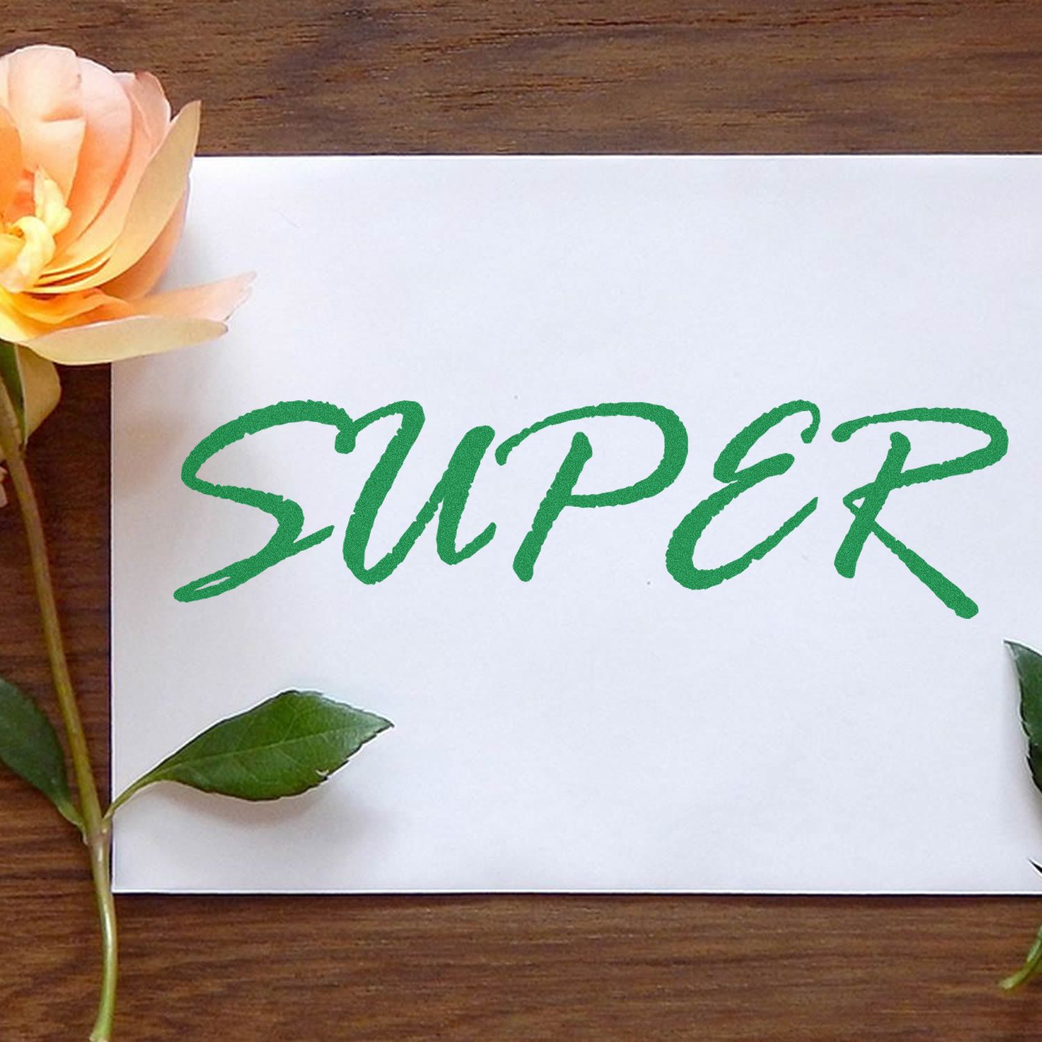 Green SUPEX logo on a white card with flowers and leaves on wood, eco-friendly brand greeting design.