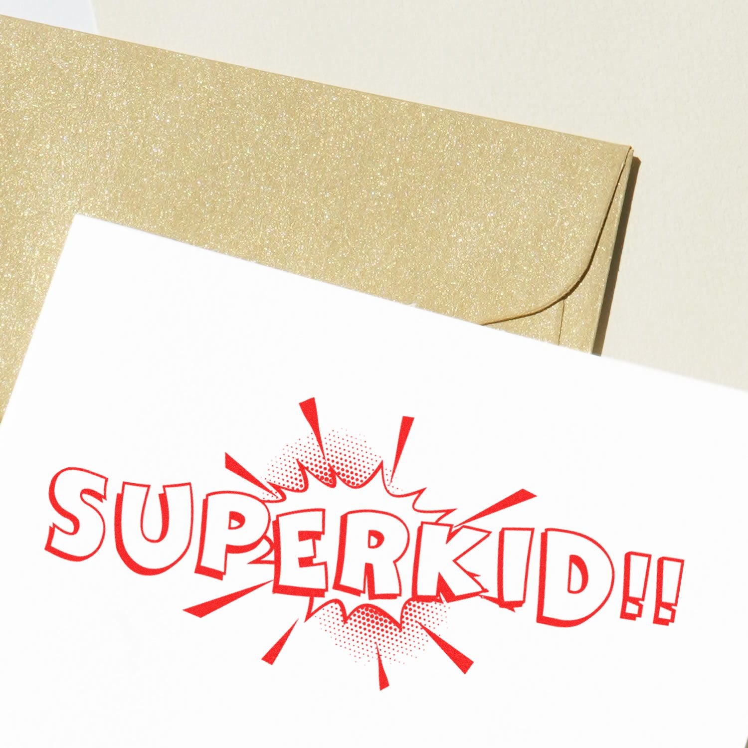 Gold glitter envelope with a white card reading SUPER KID!! in bold red comic-style text.