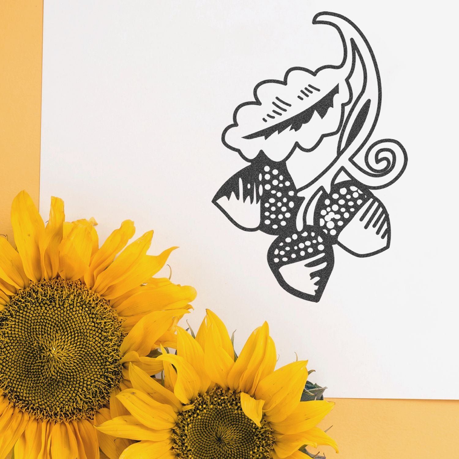 Bright sunflowers beside a black floral abstract design on a white background with yellow accents
