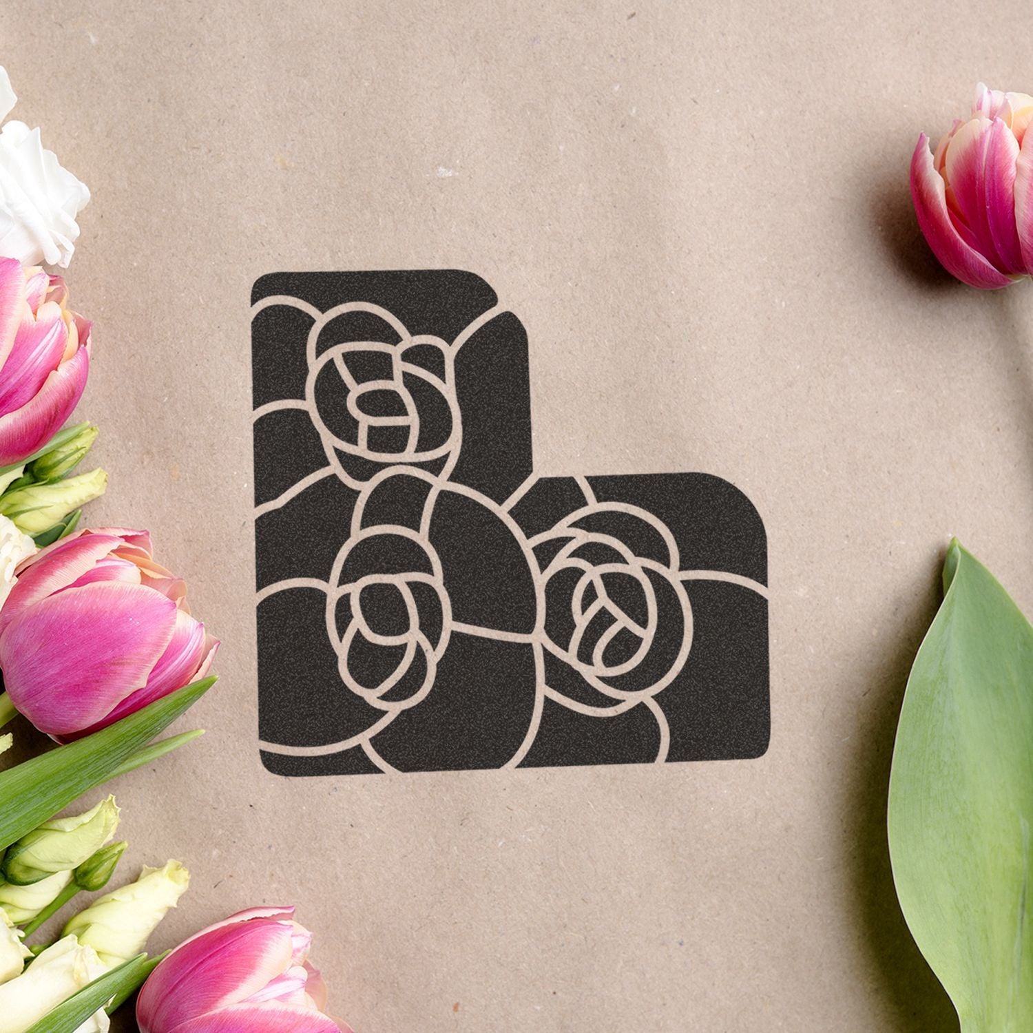 Black floral monogram letter L on kraft paper with pink tulips and green leaves border, elegant floral logo design