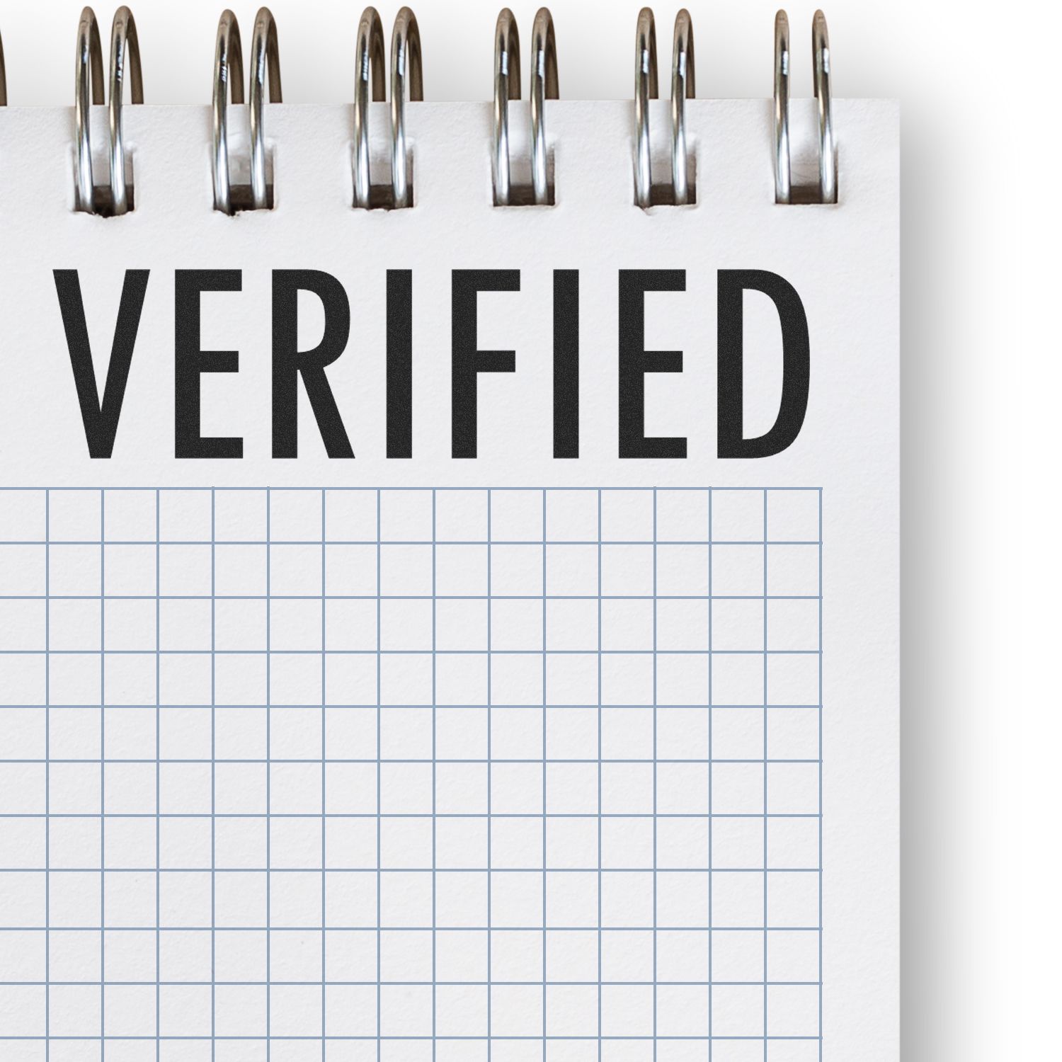 Verified stamp on lined notepad with paper clips, representing quality control and compliance documentation.