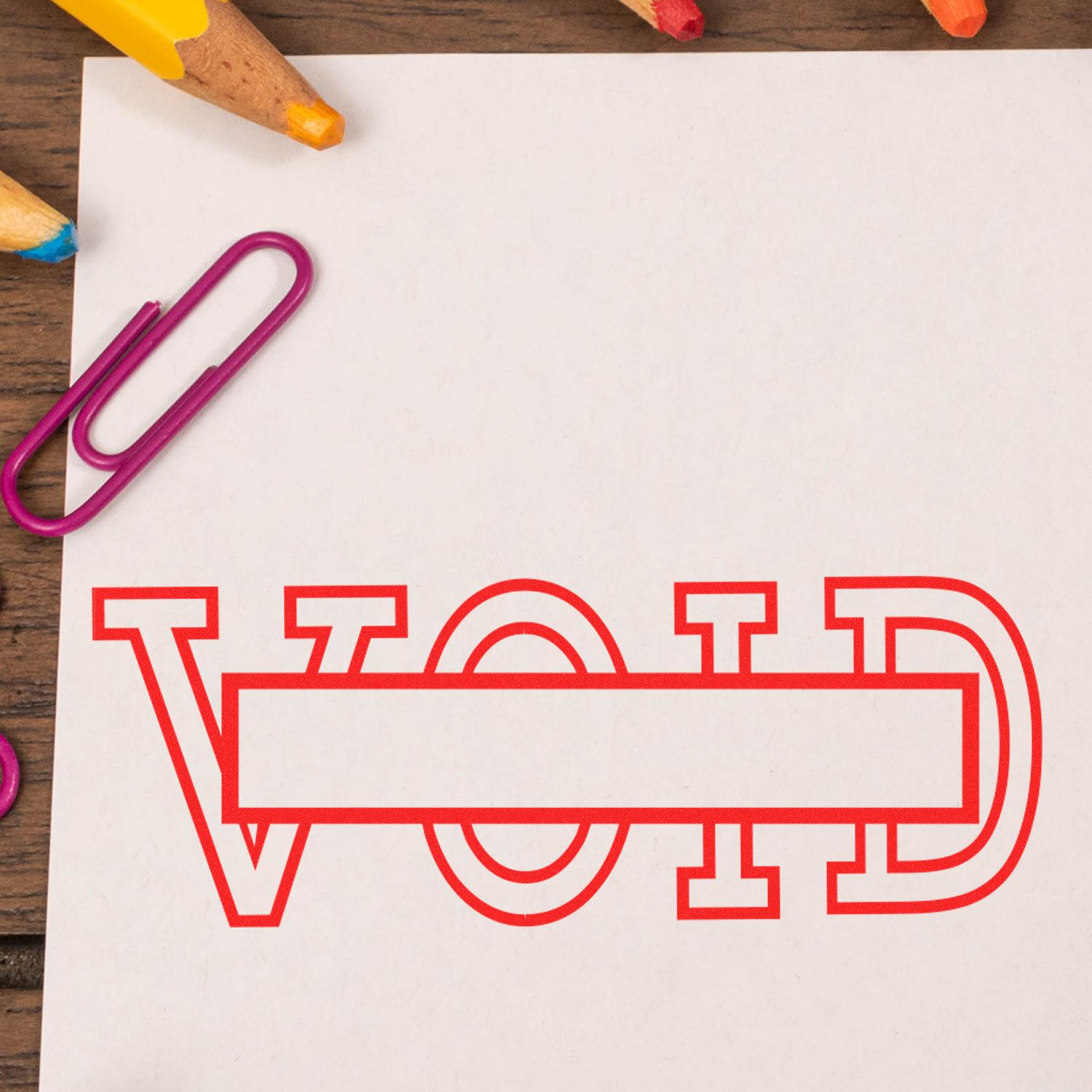 Colorful pencils and paperclip on a blank worksheet with red alphabet outlines, highlighting handwriting and learning activities for kids