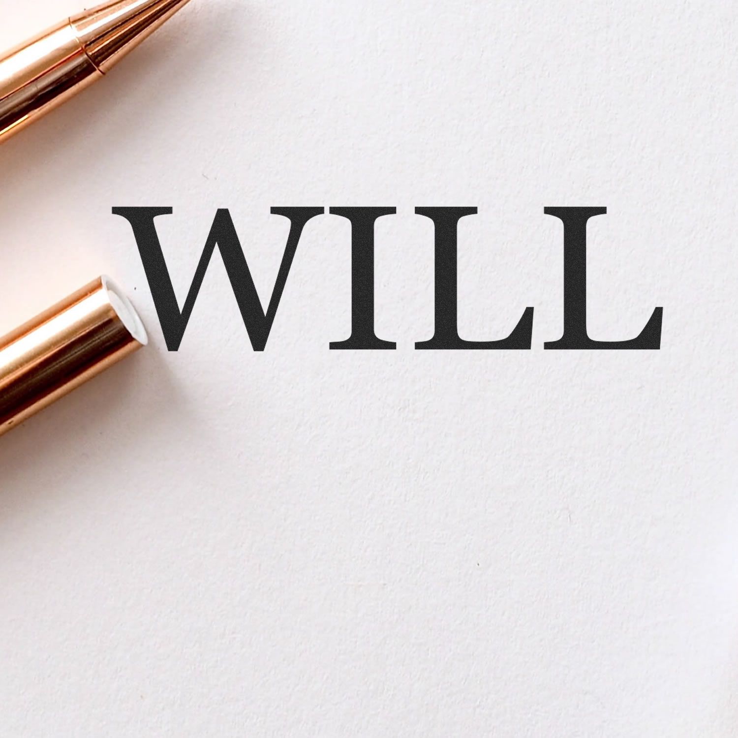 Elegant WILL typography on white paper with gold pens, minimal business and motivation concept.