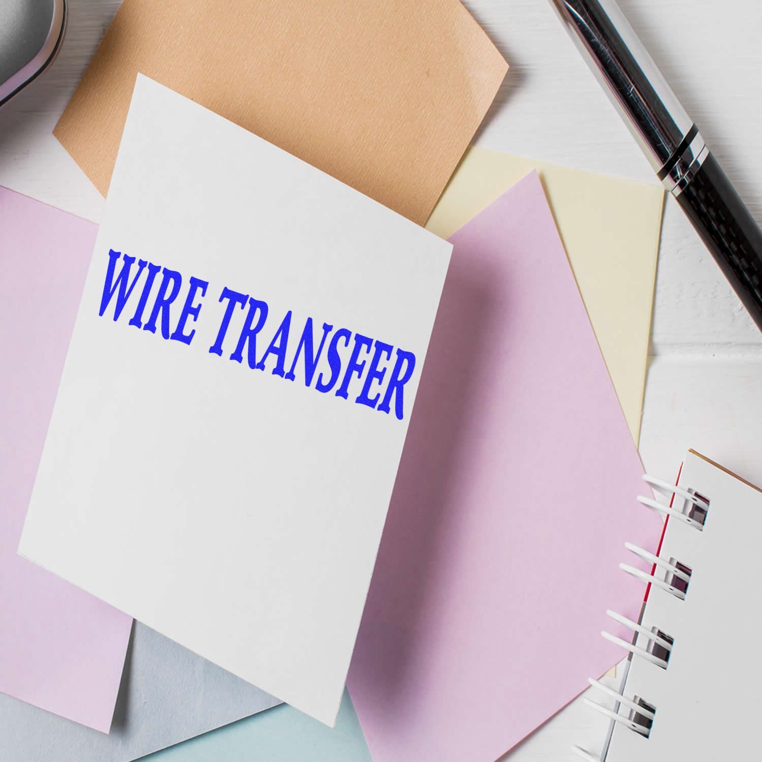 Wire transfer form on colorful stationery with pen and notebook, financial banking concept.