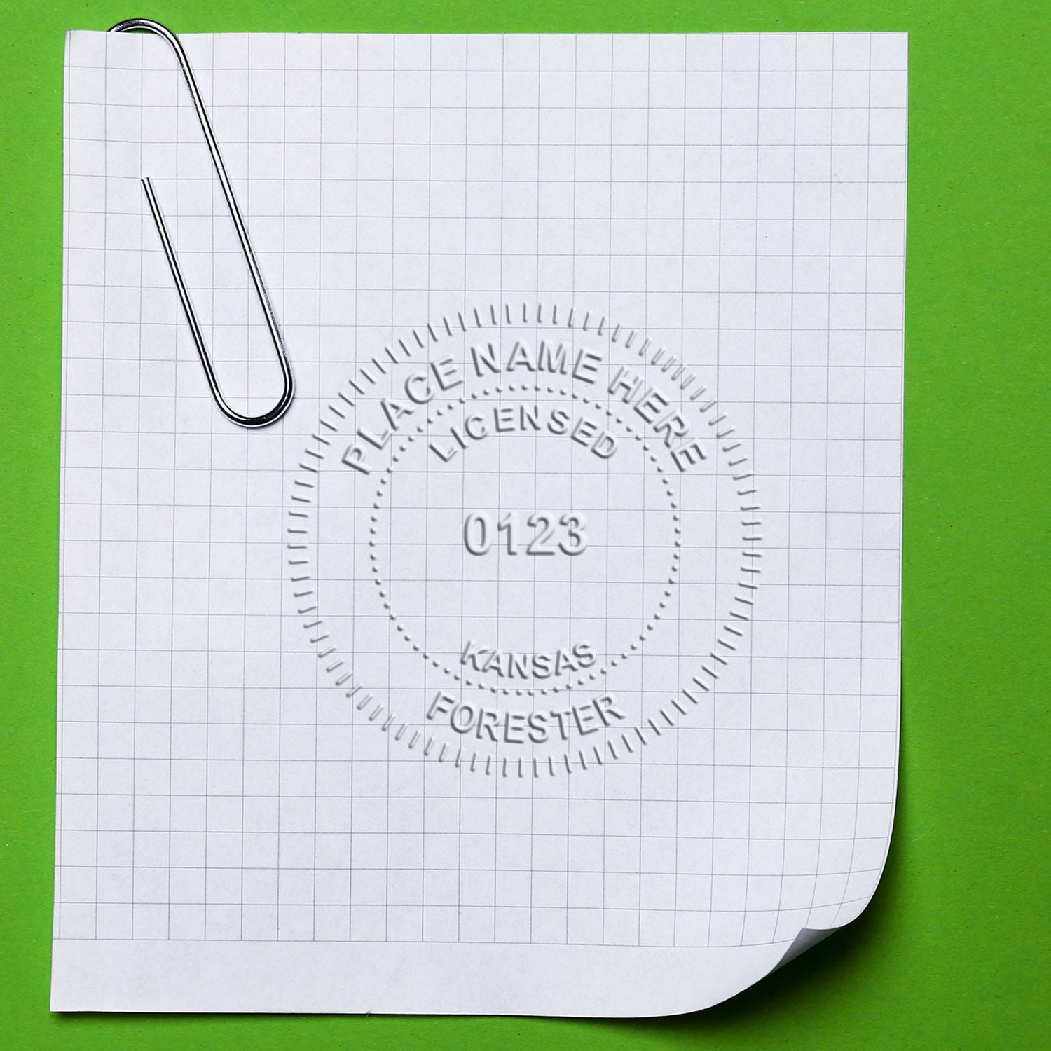 Graph paper sheet with paper clip and blank watermark logo mockup on green background