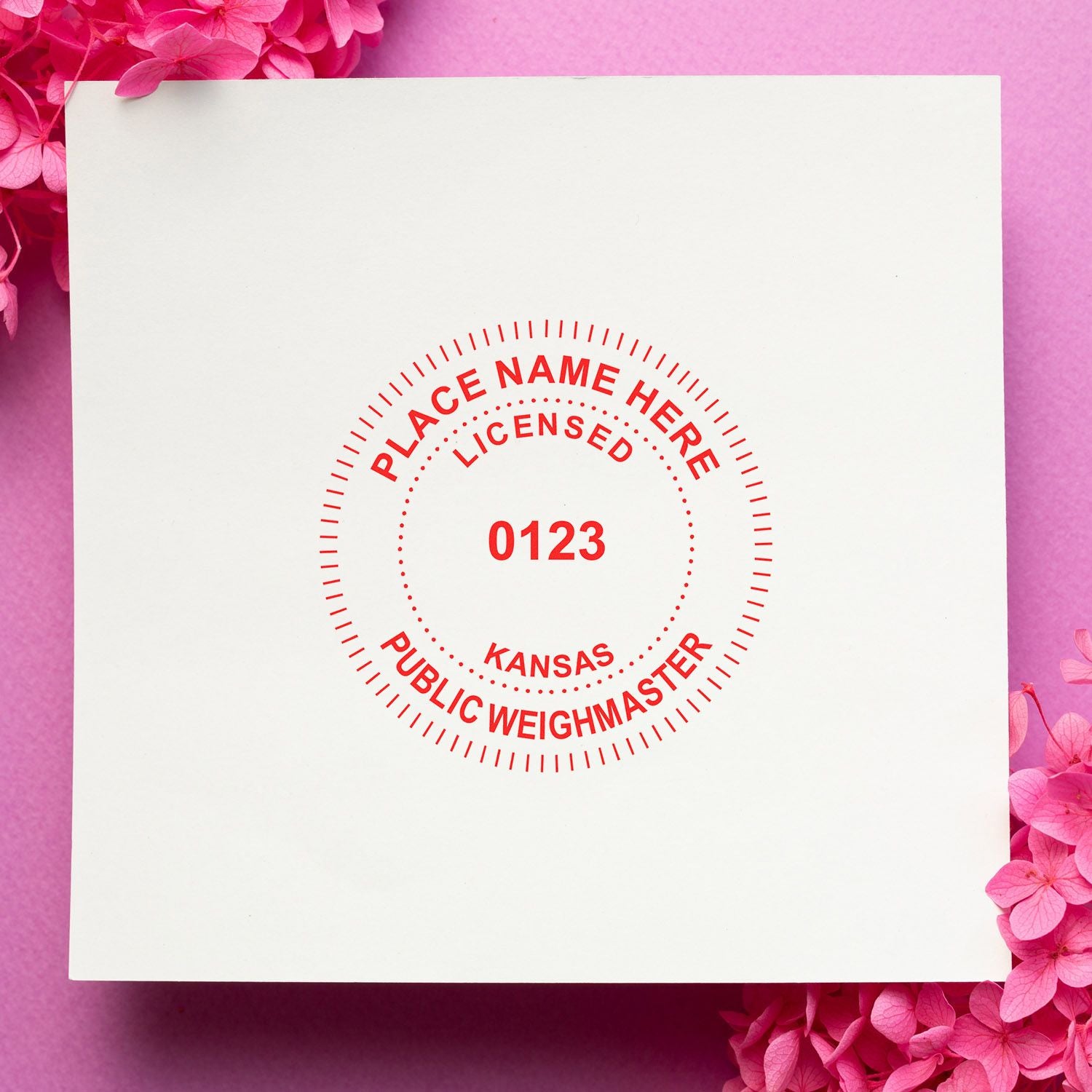 White paper mockup with red Kansas public weighmaster licensed seal on a pink floral background.