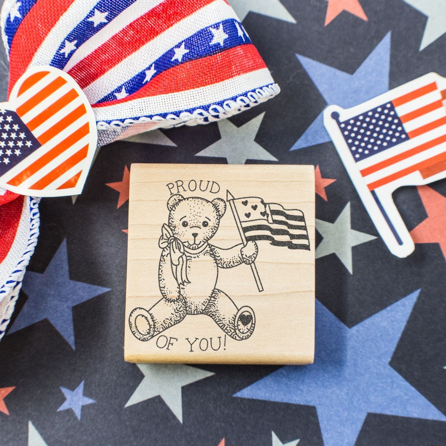 Patriotic teddy bear stamp with American flag on starry red, white, and blue background for Fourth of July celebration