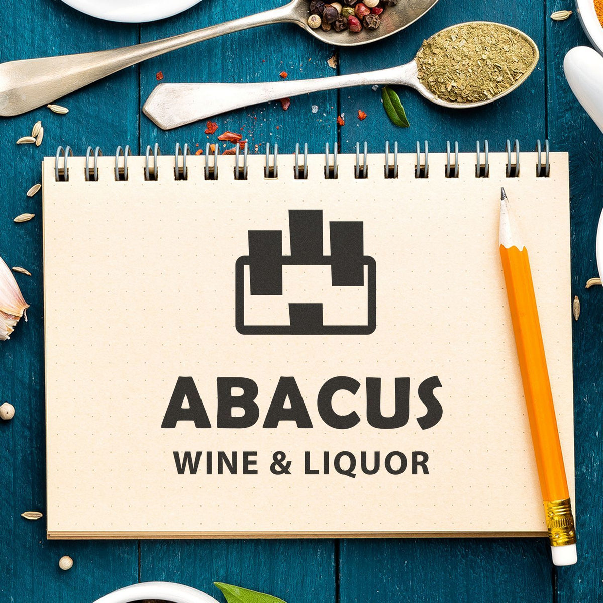 Abacus Wine & Liquor logo on a notepad with kitchen spoons, spices, and pencil on a rustic blue tabletop.