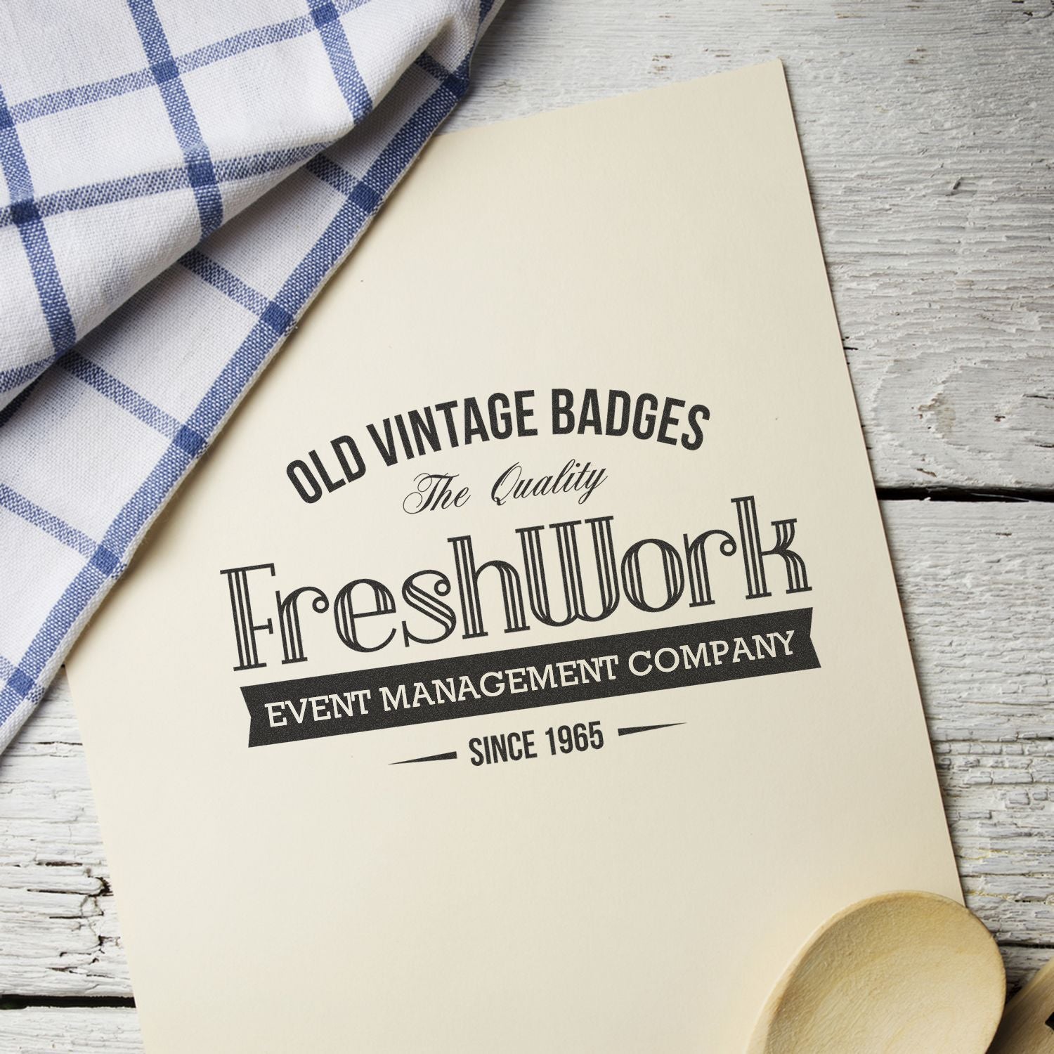 Vintage badge design template for event management company with Since 1965 text on cream card and blue checkered cloth.