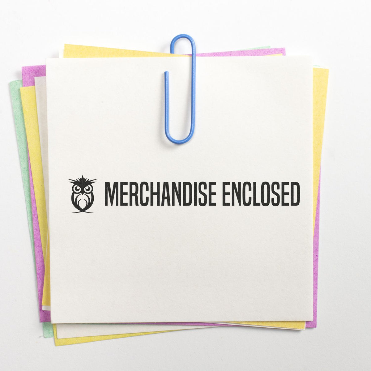 Merchandise enclosed label on stacked shipping papers with blue paperclip, indicating contents are included in the package shipment.