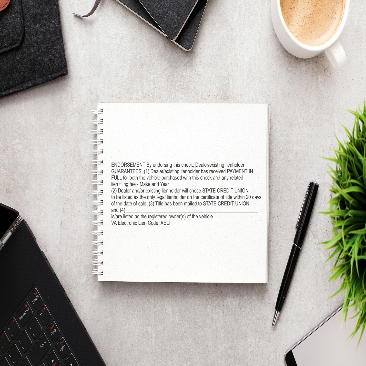 Vehicle title endorsement and lienholder guarantee paperwork on a notebook with pen and coffee, for dealer lienholder checks.