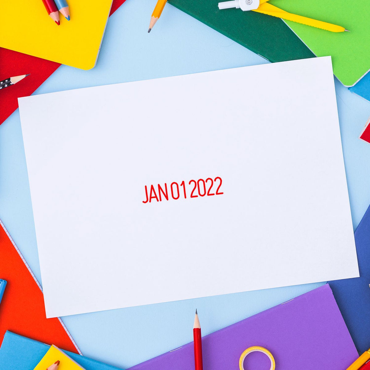 Colorful stationery surrounding a blank white page labeled JAN 01 2022 with pencils and notebooks on a blue background.