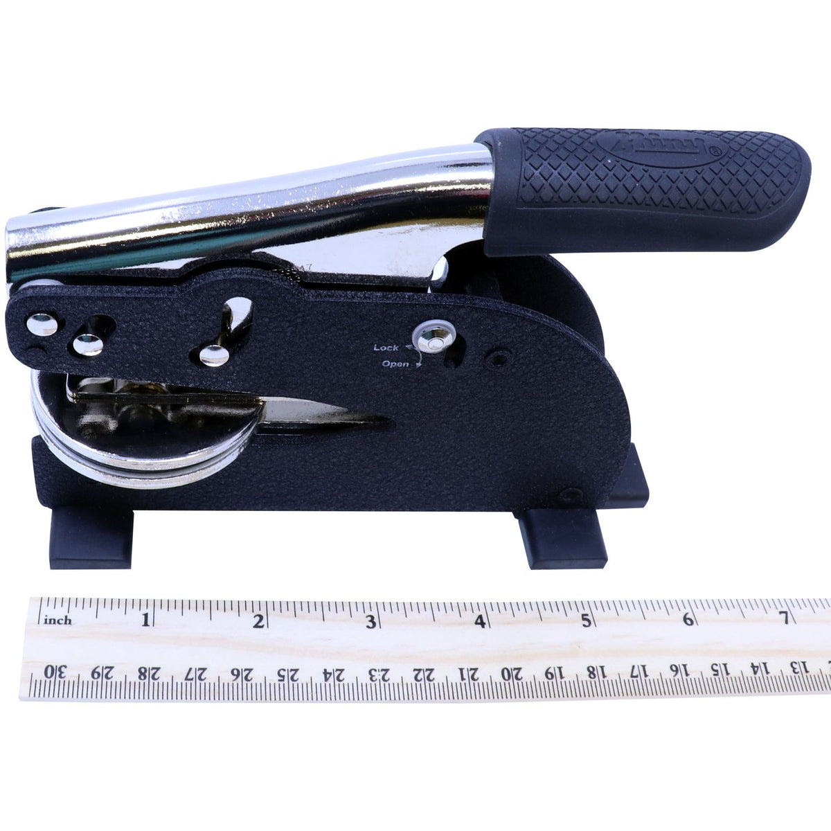 Heavy-duty black metal hole punch with chrome handle and measurement ruler for size comparison.