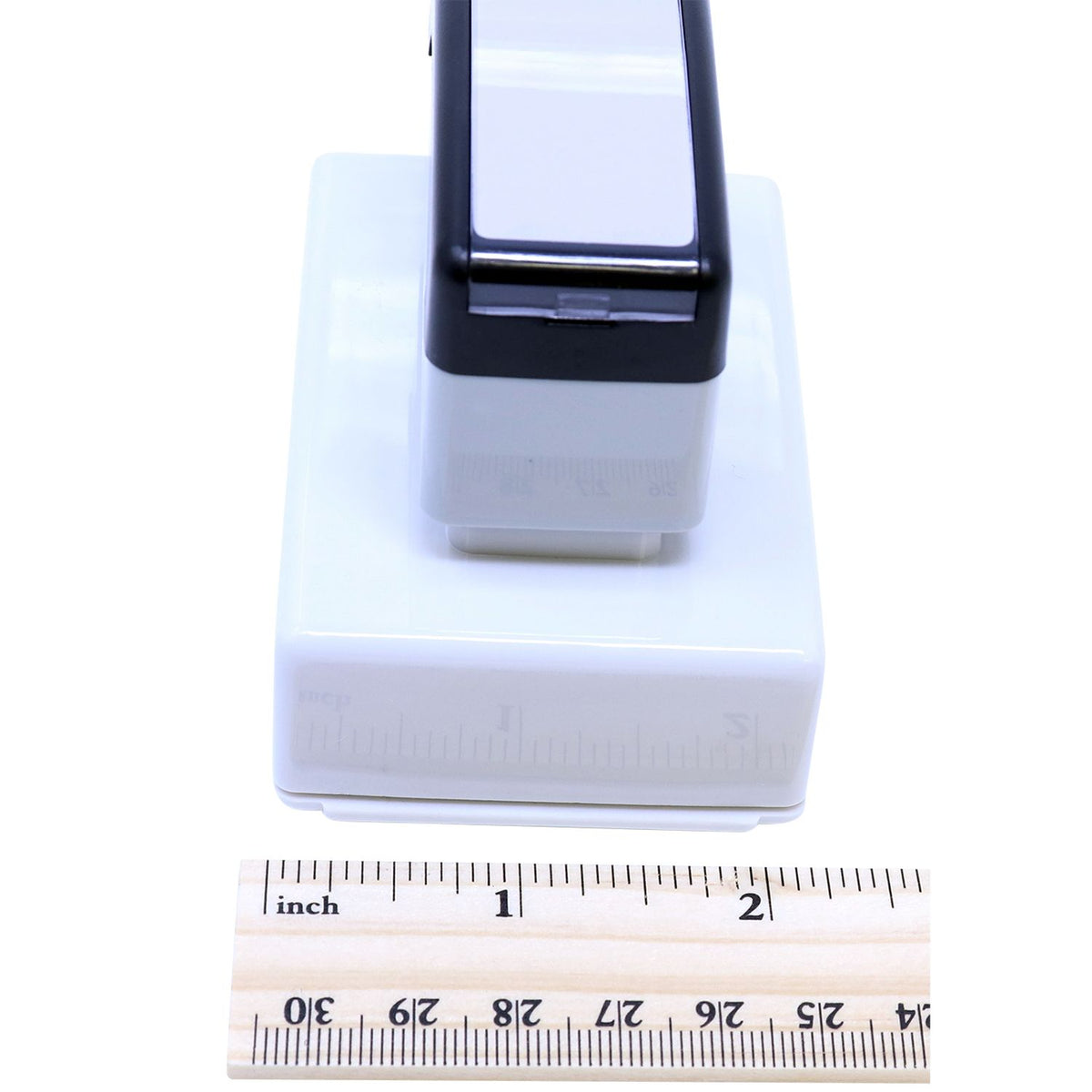 Close-up of white smartphone dock base and black holder, shown with ruler measurement scale for size.