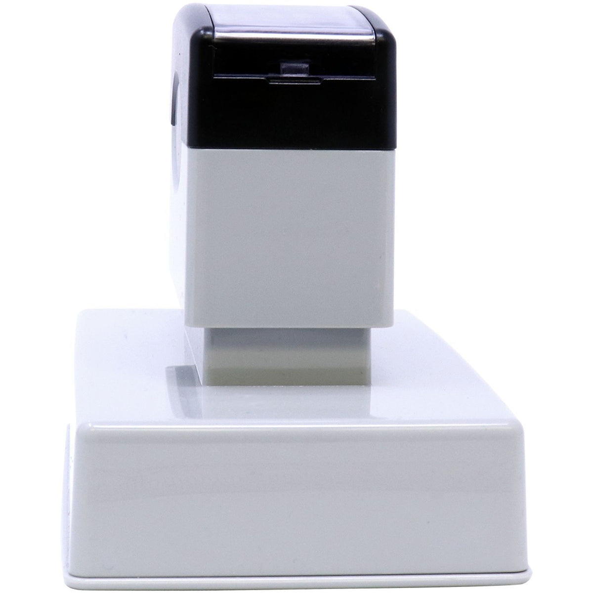 Close-up front view of compact white and black countertop electronic device with dark top opening and control window.