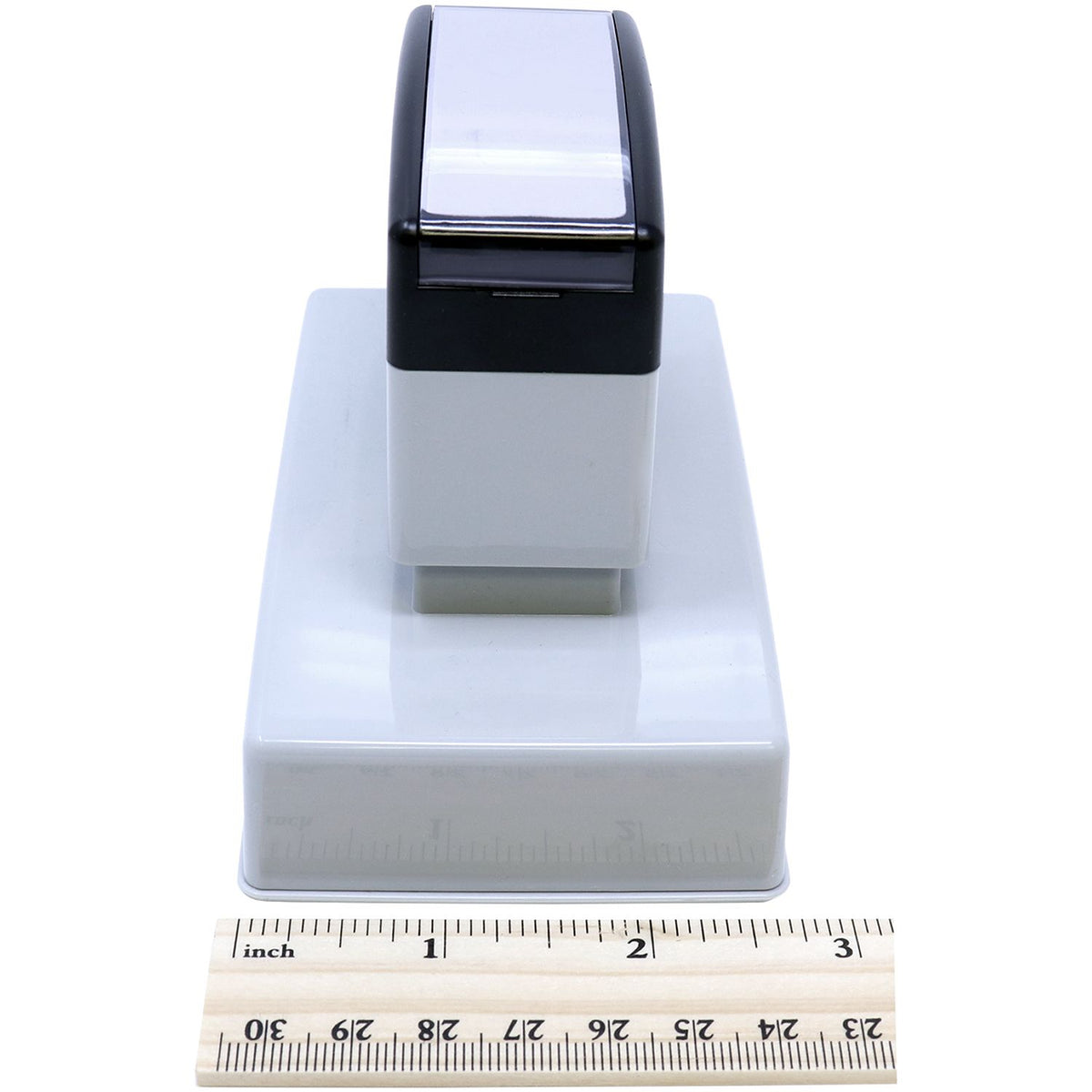 Black desktop label dispenser product close-up, measured with an inch ruler to show compact dimensions for ecommerce listings.