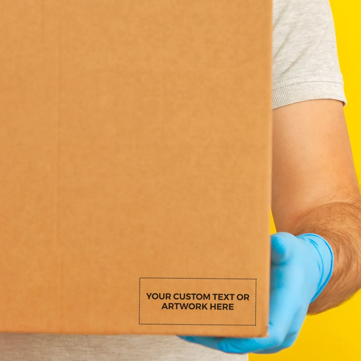Blue-gloved warehouse worker holding a cardboard shipping box against a bright yellow background for logistics and delivery service.