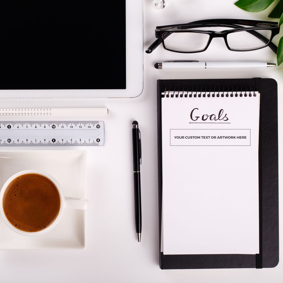 Flat lay office desk with laptop, glasses, coffee, and Goals notebook for planning, productivity, and personal goal setting.