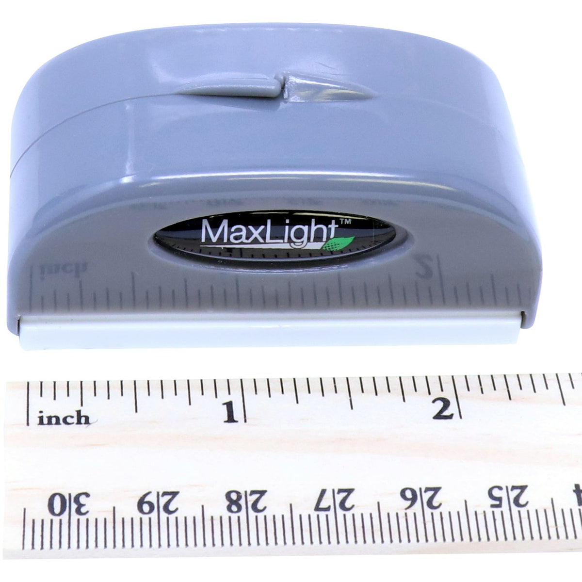 MaxLight headlamp/light tool close-up with size measured against an inch ruler for product dimensions reference.