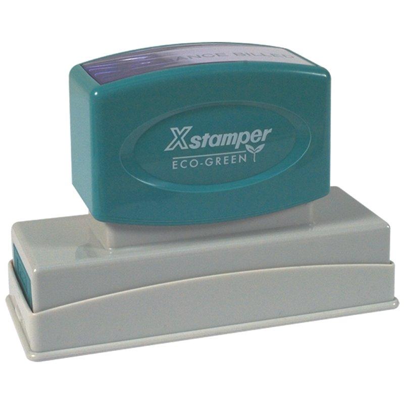 Xstamper Eco-Green self-inking stamp with green top and base, used for quick reusable date and office marking on documents.