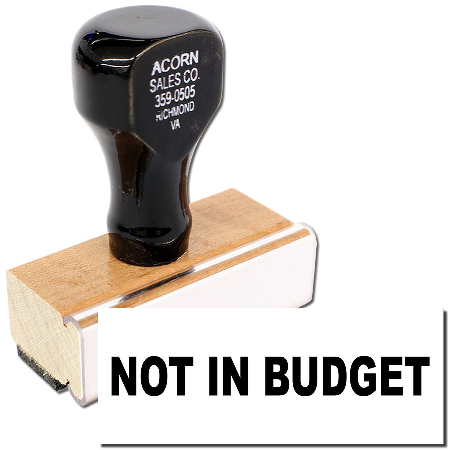 Black Acorn Sales Co. rubber stamp on wooden block with NOT IN BUDGET, highlighting budget approval rejection.