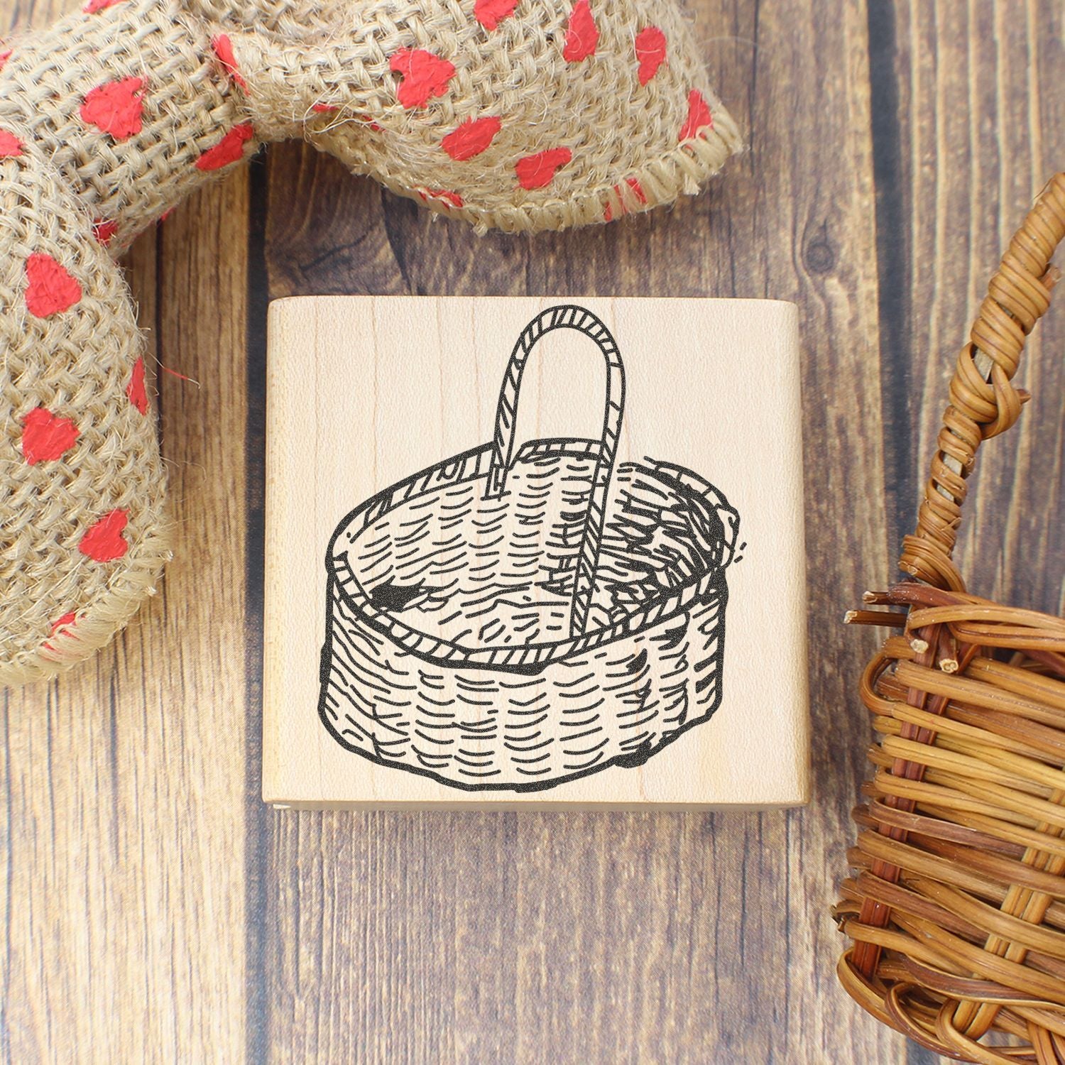 Wooden basket stamp with rustic woven decor on a wooden background, handmade craft tool close-up.