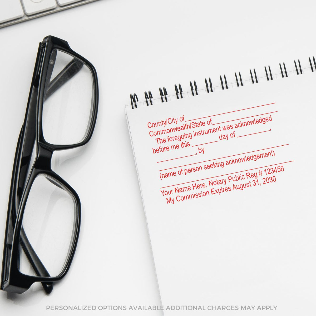Black eyeglasses beside a notary public acknowledgment stamp and notebook on a white desk, legal office stationery close-up.